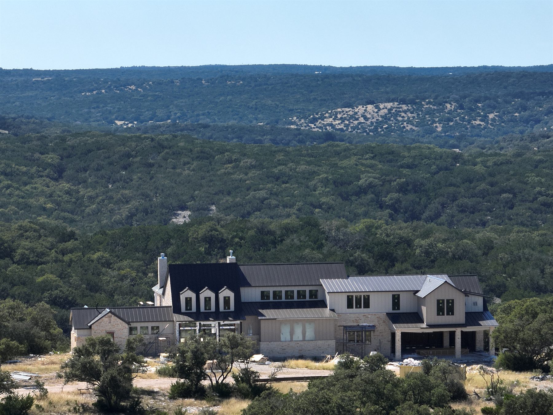 The lodge at 3 Hollows Ranch set against Hill Country ridgelines