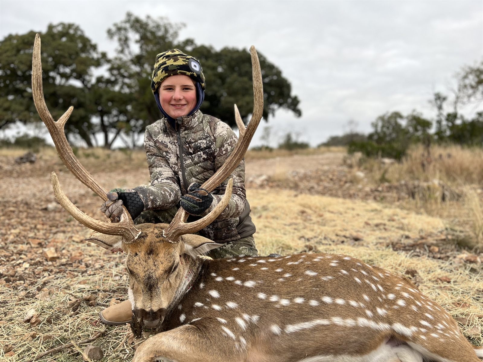 A young hunter with an axis buck